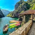 Kayaks and traditional boats at the Matka Canyon lakeside surrounded by limestone cliffs near Skopje, North Macedonia.